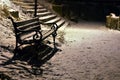 Snow covered bench in the winter at night Royalty Free Stock Photo