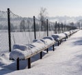 Snow-covered benches by the soccer field