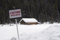 Snow covered boat house in Lake Louise with warning sign in the front Royalty Free Stock Photo