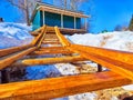 Snow-Covered Boat Launch Ramp With Adjacent Storage Shed. Wooden boat ramp with snow and a green storage shed Royalty Free Stock Photo