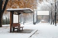 Snow-covered bus stop next to a park with a blank street billboard during winter snowfall