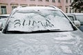 Snow covered car. In the snow, the finger says `Winter`