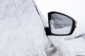 Snow-covered car in open parking lot.