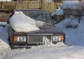 Snow-covered car in the parking lot urban scene after a snowstorm