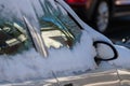 Snow covered car windows after blizzard and snowstorm show icy windows and danger due to extreme weather phenomenon with snowdrift Royalty Free Stock Photo