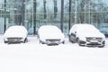 Snow covered of cars in the parking lot. Urban scene, snowstorm. Clean automobile from the snow Royalty Free Stock Photo