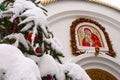 Snow-covered Christmas tree branch on the background of the Orthodox icon and the cross. Orthodox Church Winter - Christmas. Royalty Free Stock Photo