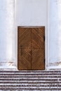 Snow-covered cobblestone stairs to a brown wooden door Royalty Free Stock Photo