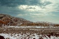 Scenic snow covered of desert mountain along I-40 highway with asphalt road in winter New Mexico Royalty Free Stock Photo