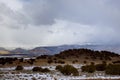 Scenic snow covered of desert mountain along I-40 highway with asphalt road in winter New Mexico Royalty Free Stock Photo