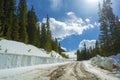 Snow Covered Dirt Road by a Snowbank in the Mountains