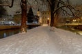 Snow-covered evening park alley between two channels Royalty Free Stock Photo