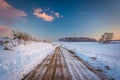 Snow covered field along a dirt road at sunset, in rural York Co Royalty Free Stock Photo