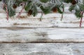 Snow covered fir tree branches with gold and silver pine cone decoration ornaments on white rustic wood Royalty Free Stock Photo