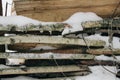 Snow-covered firewood stacked under a canopy, firewood for the winter. Winter landscape Royalty Free Stock Photo