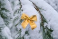 Snow covered Gold tied bow on fir branch on winter snowy background with copy space. Merry Christmas Happy New Year Royalty Free Stock Photo