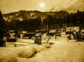 Snow covered ground in winter. Town with night sky and full moon Royalty Free Stock Photo