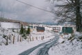 Snow-covered highway in a village with colorful houses in a mountain valley