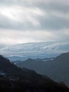 Snow covered hills and moorland surrounded by a forest valley in the west yorkshire dales with white winter clouds Royalty Free Stock Photo