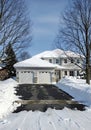 Snow covered house with garage and driveway winter Royalty Free Stock Photo