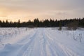 Snow- covered lake at dawn with boats on the shore. Winter forest with snow-covered fir trees high in the mountains. Sunny Royalty Free Stock Photo