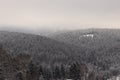 Snow-covered landscape. Grey fog. Mysterious atmosphere in winter time. Grey sky and amazing snowflakes falls the ground and hills