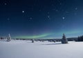 Snow-covered landscape at night featuring a starry sky with constellations and a Royalty Free Stock Photo