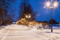 Snow-covered lanterns, benches and trees in the winter Park Royalty Free Stock Photo
