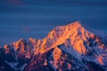 Snow covered mountain in the Alps catches the last rays of sunlight