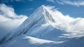 Snow-Covered Mountain Peak with Clouds and Blue Sky Royalty Free Stock Photo