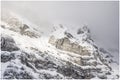 Snow covered mountain peak with little visibility due to cloud cover and snowfall. Royalty Free Stock Photo