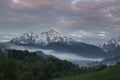 Snow covered mountain peak of Watzmann and city Berchtesgaden with clouds and morning fog during sunrise, Bavaria Royalty Free Stock Photo