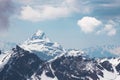 Snow-covered mountain peaks and sky with white clouds. Beautiful winter landscape Royalty Free Stock Photo