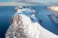 Snow covered mountain range on coastline in winter, Norway. Senja panoramic aerial view, Troms county, Fjordgard