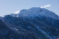 Snow covered mountains, clear blue skies and rocky peaks in the Alps. Winter scene.