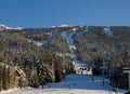 Snow covered mountains panorama - snowboarders and skiers ride on slopes and ski lifts. Ski resort in Whistler, Canada Royalty Free Stock Photo