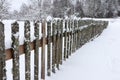 Snow covered old wooden fence with moss in the park Royalty Free Stock Photo