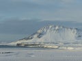 Snow-covered open field with a distant mountain view in Iceland