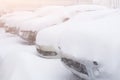 Snow covered ows of cars in the parking lot. Urban scene, snowstorm. Clean automobile from the snow Royalty Free Stock Photo