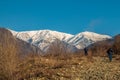 Snow covered peaks at high landscape with dried stone ground foreground.