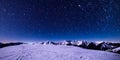 The snow-covered peaks serve as the perfect stage for a dazzling sky full of stars Royalty Free Stock Photo