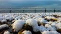 Snow covered pebble beach at sunrise on a frozen winters morning