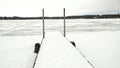 Snow Covered Pier Leading out to Lake