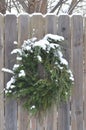 Snow covered pine juniper wreath wood fence gate Royalty Free Stock Photo