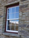 Snow covered range reflected in historic stone cottage window, New Zealand Royalty Free Stock Photo