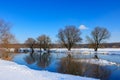 Snow-covered river bank on a sunny winter evening. Winter landscape Royalty Free Stock Photo