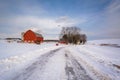 Snow covered road and red barn on a farm in a rural area of York County, Pennsylvania Royalty Free Stock Photo