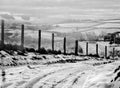 A snow covered rural landscape with a narrow single lane road Royalty Free Stock Photo