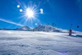 Snow-Covered Ski Slope and Ski Lift and Bright Sun Royalty Free Stock Photo