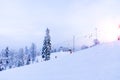 Snow-covered ski slope in the mountains with a lift and skiers skating away Royalty Free Stock Photo